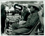 F10_E10_01 Gordon Parks sits behind a movie camera on location for "The Learning Tree" in Bourbon and Linn counties, Kansas by Unknown
